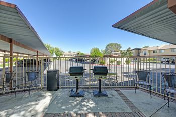 a patio with tables and chairs and a fence